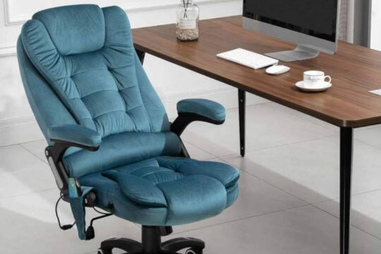An alberto velvet office chair in blue is sat in front of a desk in an office environment.